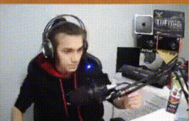 a man wearing headphones is talking into a microphone .