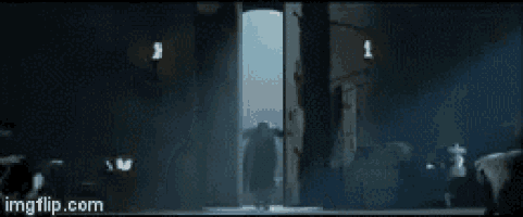 a person in a gas mask is standing in a doorway .