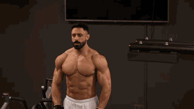 a shirtless man with a beard is lifting a barbell