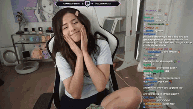 a woman is sitting in a chair with her hands on her face while watching a live stream