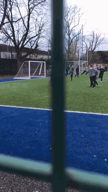 a group of people are playing soccer on a blue field