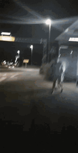 a blurry picture of people walking in front of a mcdonalds