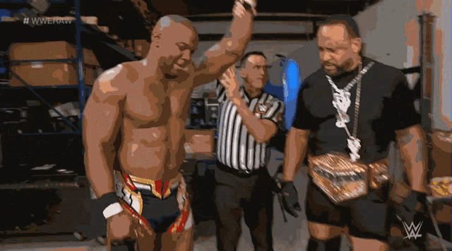 a wrestler is being congratulated by a referee while wearing a wrestling belt