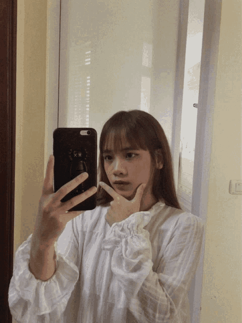 a woman taking a picture of herself in a mirror