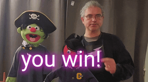 a man standing next to a pirate puppet with the words " you win " behind him