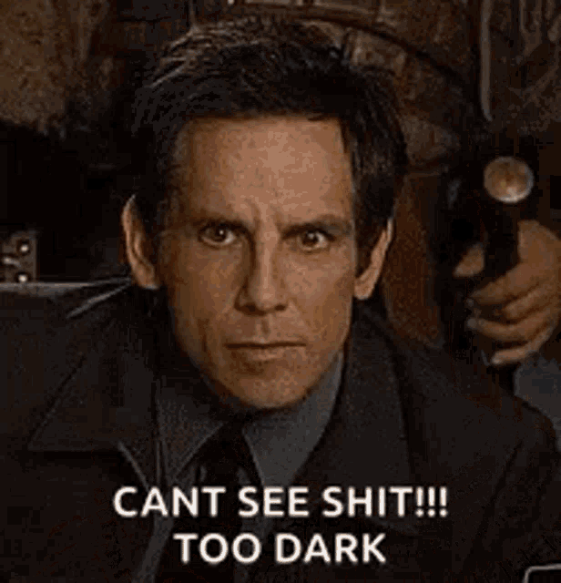 a man with a mustache and glasses is wearing a hat and uniform and says `` cant see shit too dark '' .