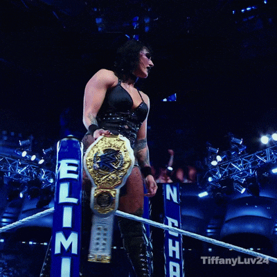 a female wrestler stands in a ring with tiffanyluv24 on the bottom right
