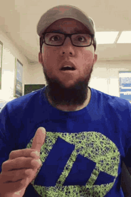 a man with a beard and glasses is wearing a blue shirt that says idc