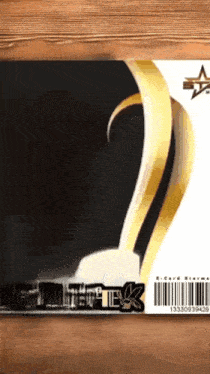 a black and gold e-card sitting on a wood table