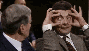a man in a suit and tie is making a funny face .