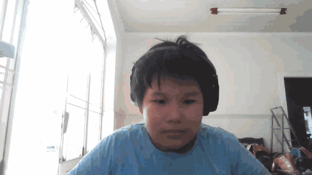 a young boy wearing headphones is looking at the camera