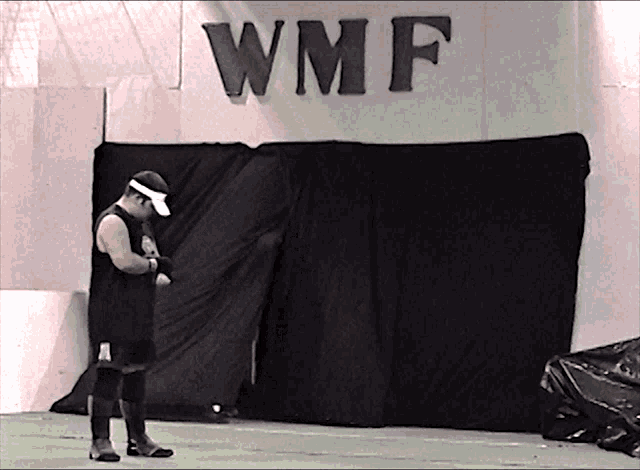 a man standing in front of a wall that says wmf on it