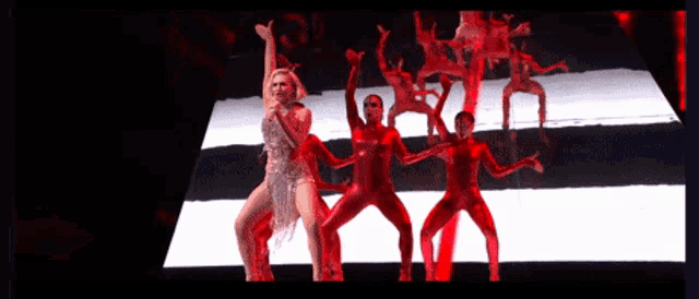 a woman in a silver dress is singing on stage