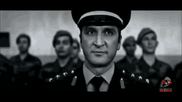 a man in a military uniform stands in front of a group of other men