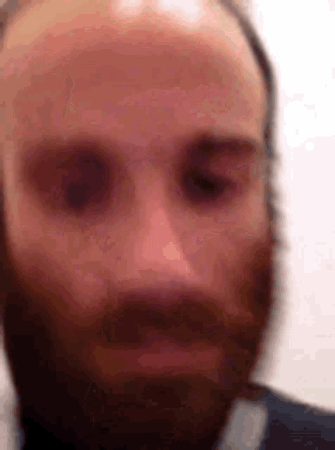 a close up of a man with a beard and bald head .