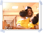 a man wearing a hat is holding two children