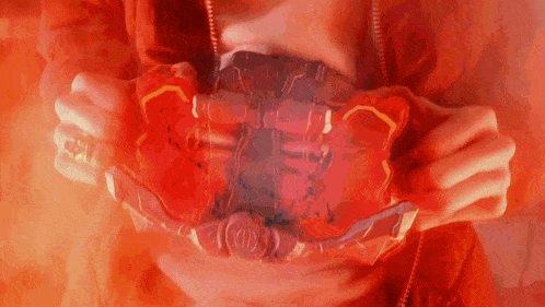 a person in a red jacket is holding a red object with the letter o on it