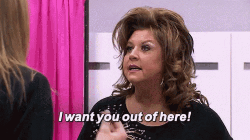 a woman is talking to another woman in a room and saying `` i want you out of here '' .