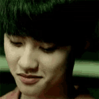 a close up of a young boy 's face with his eyes closed .
