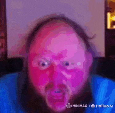 a man with a beard and a blue shirt is making a funny face with a watermark that says minimx