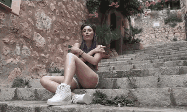 a woman with purple hair sits on a set of steps