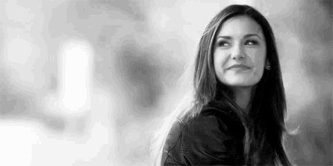 a black and white photo of a woman smiling .