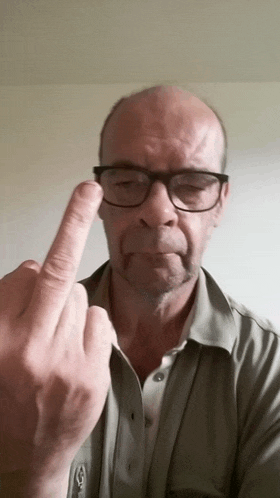a man wearing glasses is giving the middle finger to the camera