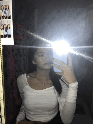 a girl takes a selfie in front of a mirror