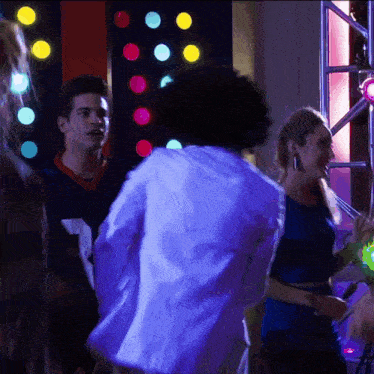 a man in a white jacket is dancing with a woman