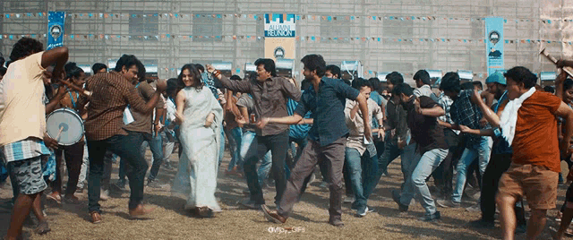 a group of people dancing in front of a sign that says reliance deccan