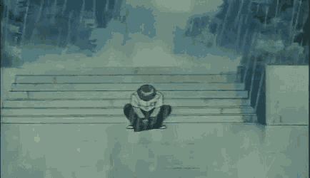 a boy is sitting on the stairs in the rain .