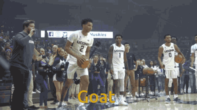 uconn basketball players on the court with the word goat in the foreground