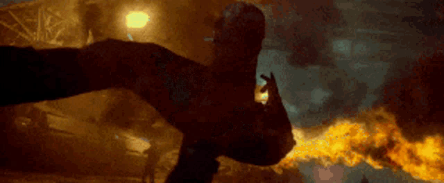 a man is flying through the air in front of a fire