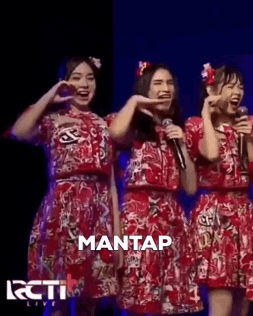 three girls are standing next to each other on a stage with microphones .