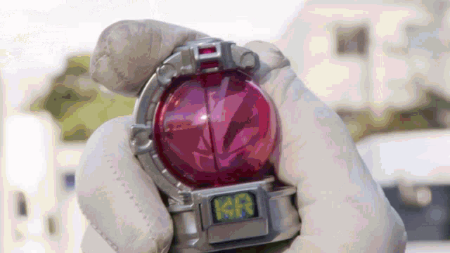 a person is holding a purple object with the letter a on the top