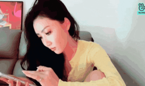 a woman sitting on a couch looking at her phone