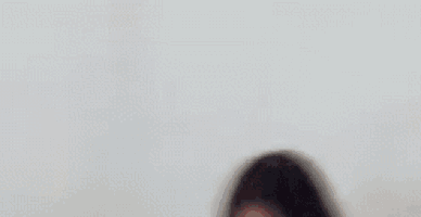 a blurry picture of a woman 's face with a dog in the background .