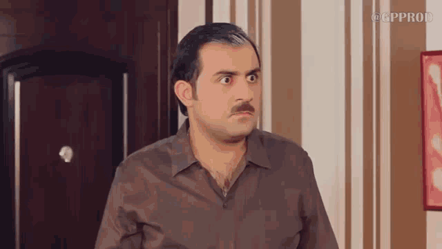 a man with a mustache is standing in front of a door with gpprod written on the bottom of the screen