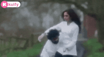 a man and a woman are standing next to each other in a field .