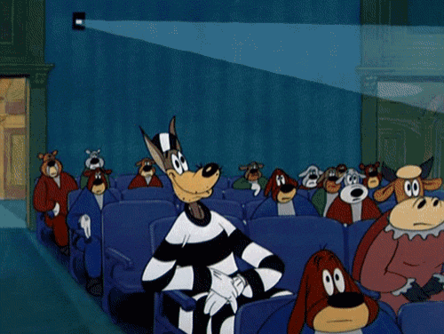 a group of cartoon dogs are sitting in a theatre watching a movie