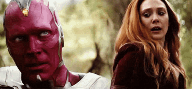 vision and scarlet witch are standing next to each other and looking at the camera .