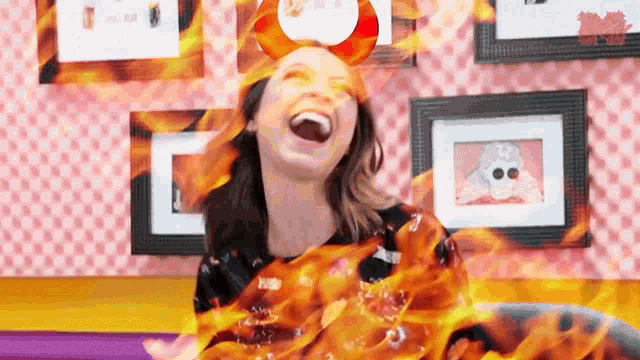 a woman is laughing with flames coming out of her body