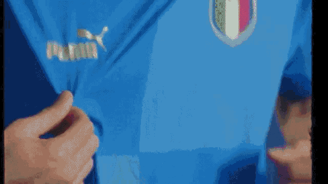 a close up of a person wearing a blue shirt with the italian flag on it .
