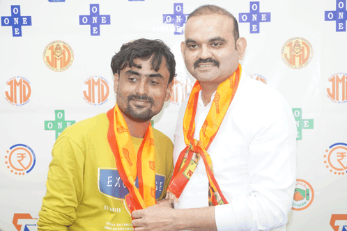 two men are posing for a picture with one wearing a shirt that says exchange
