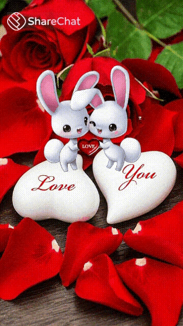a couple of bunny rabbits sitting on a heart that says love you
