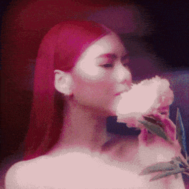 a woman with red hair is holding a white flower in her hand