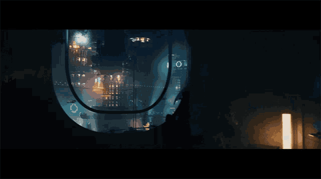 a dark room with a circular window and a few lights on