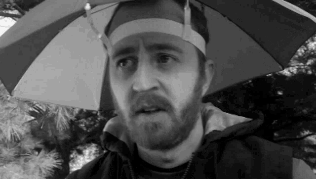 a man with a beard wearing a hat with an umbrella attached to it