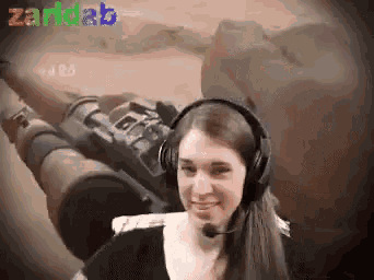 a woman wearing headphones and a microphone is smiling in front of a tank with the word zaridab written on the bottom