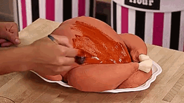 a turkey shaped cake is being decorated with sauce